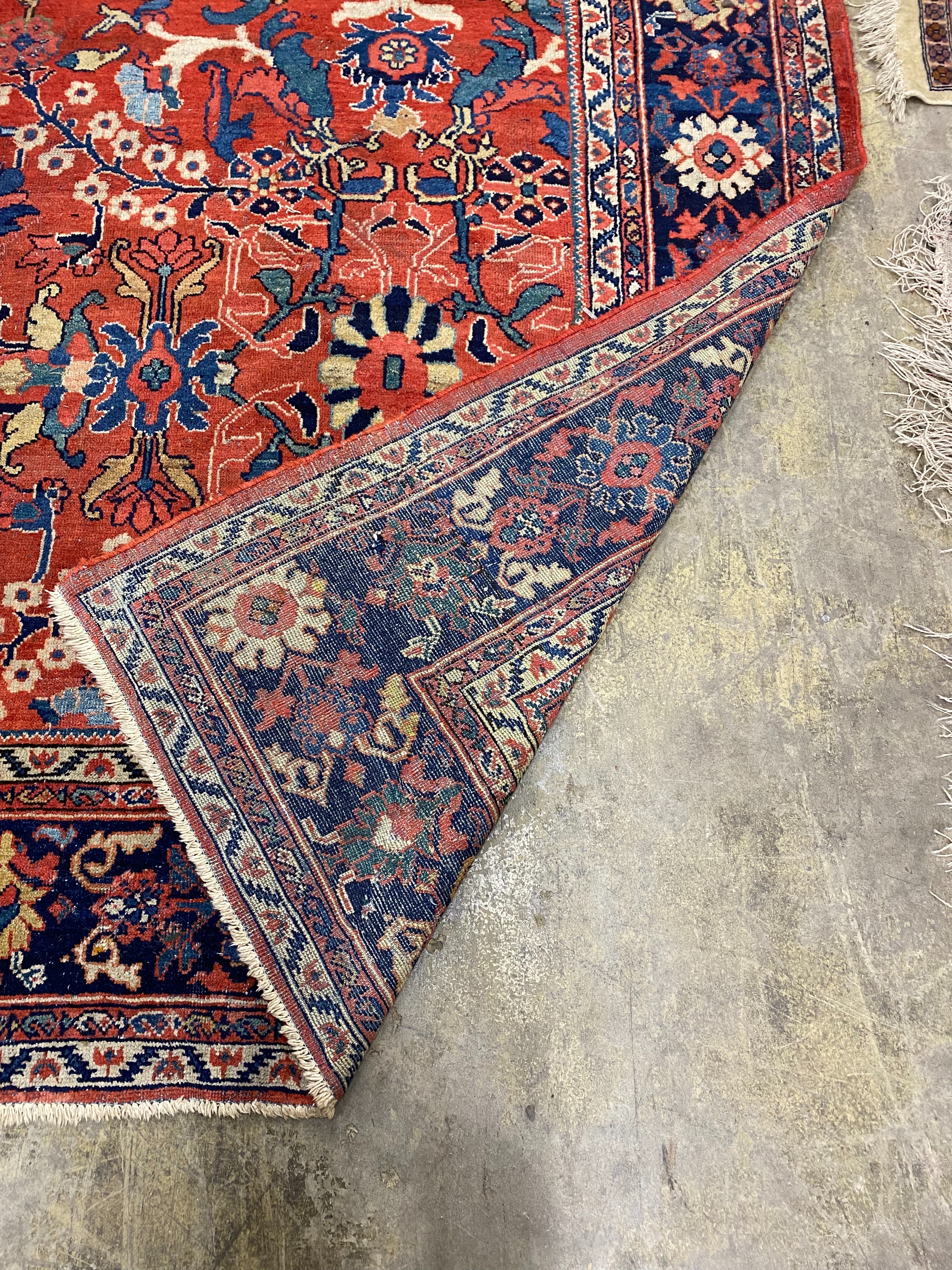 A Heriz brick red ground carpet, 364 x 280cm